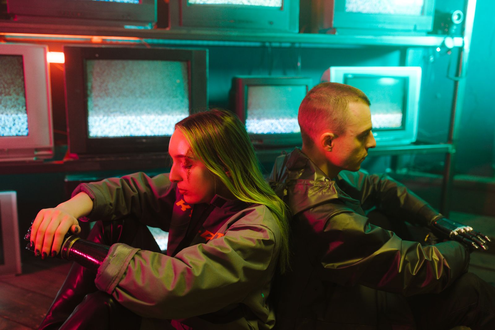 Une scène futuriste capturant deux individus dans un cadre cyberpunk entourés de téléviseurs.